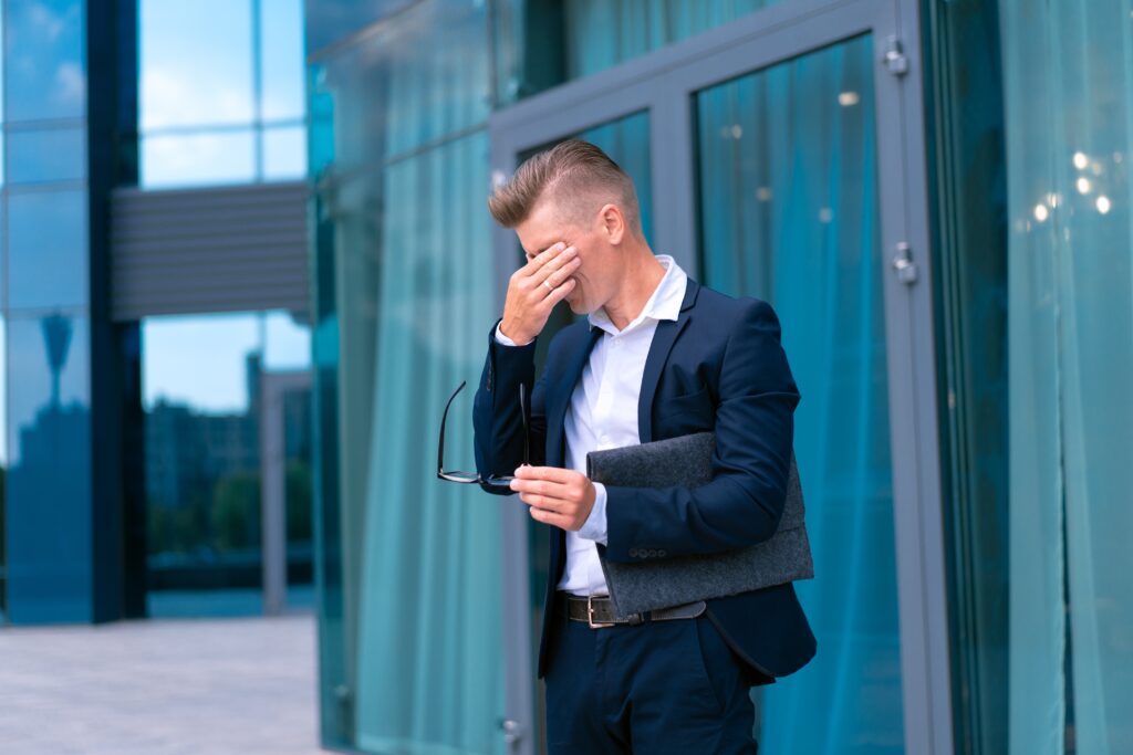 Stressed businessman holding his head outside an office building