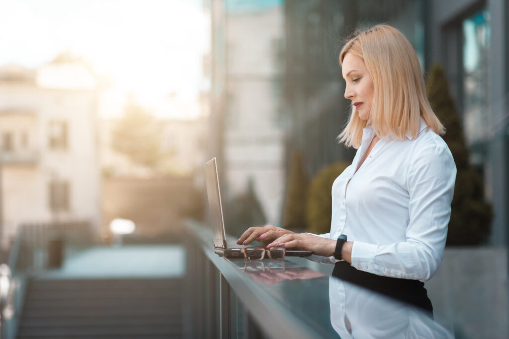 Businesswoman working on a laptop outdoors