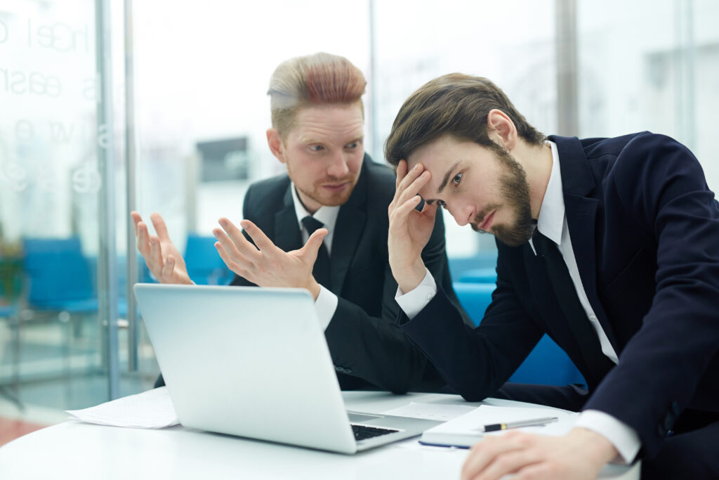 Two frustrated businessmen discussing a problem in the office