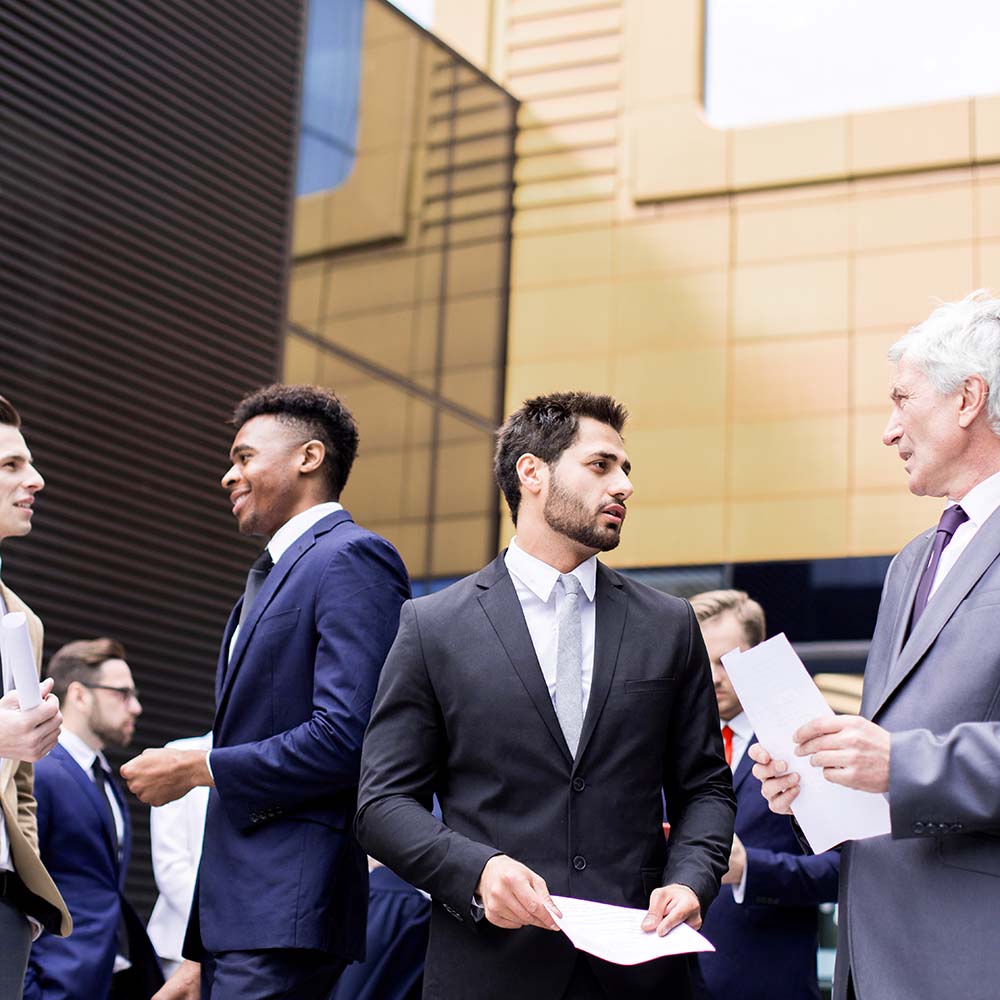 Business professionals networking and discussing outside an office building